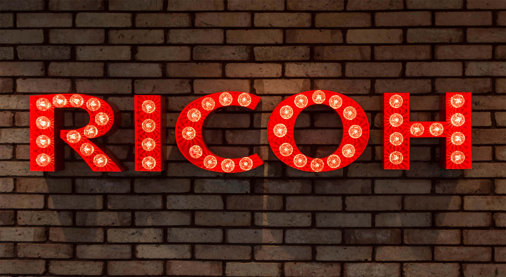 RICOH - letters with light bulbs on a brick wall